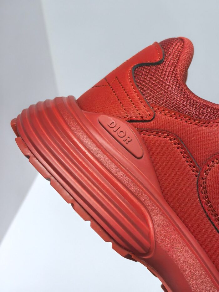 Sneaker rossa moderna, design sportivo, suola ruvida, materiali sintetici e tessuto, stile dinamico.