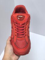 Scarpe da corsa rosse in mesh e sintetico con suola antiscivolo e design sportivo moderno.