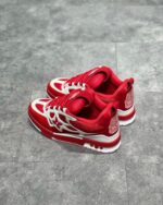 Sneakers rosse alla moda con dettagli bianchi, suola elevata e design dinamico.