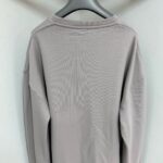 Maglietta a maniche lunghe beige minimalista per uomo e donna, stile casual e versatile.