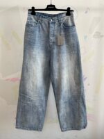 Jeans donna in denim chiaro, stile vintage, vestibilità ampia e vita alta, su appendiabiti.