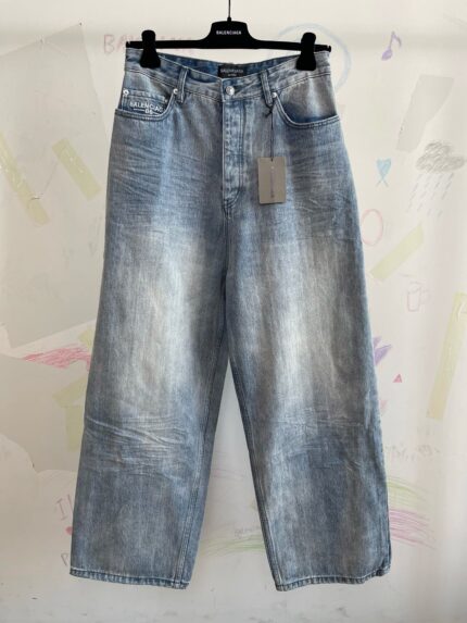 Jeans donna in denim chiaro, stile vintage, vestibilità ampia e vita alta, su appendiabiti.