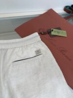 Pantaloncini chiari relax con dettagli in contrasto e tasca posteriore, perfetti per casual e sporty.