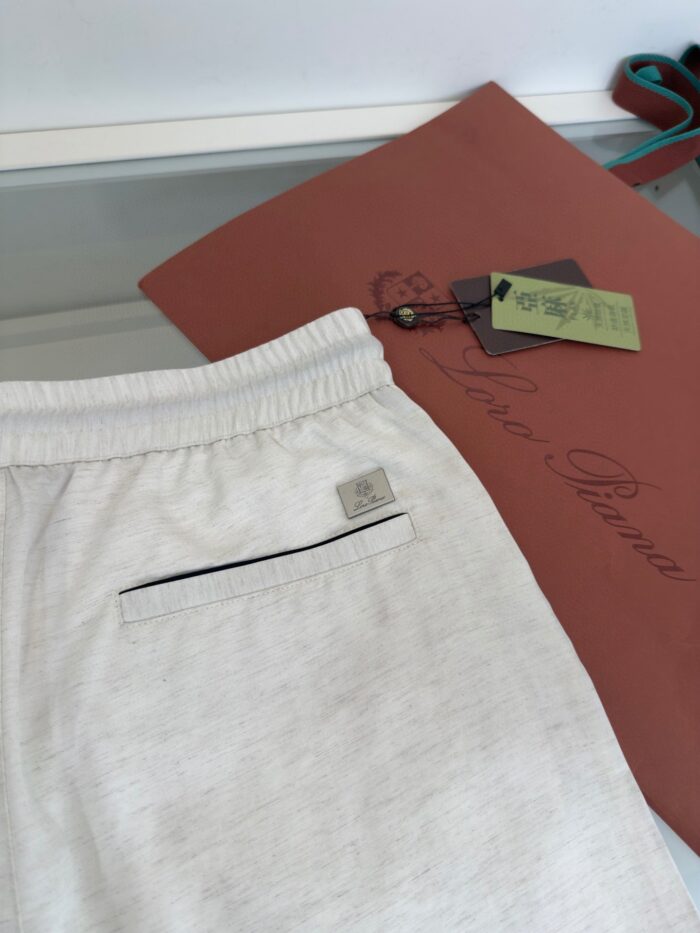 Pantaloncini chiari relax con dettagli in contrasto e tasca posteriore, perfetti per casual e sporty.