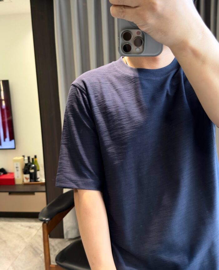 Selfie casual in soggiorno con maglietta blu e ambiente moderno e minimalista.