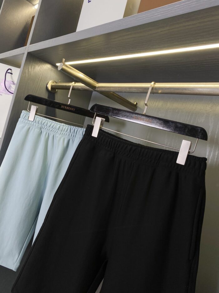 Pantaloncini casual blu e neri su espositore moderno, perfetti per estate e stile versatile.