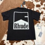 Maglietta nera Rhude con logo grafico bianco sul retro, stile streetwear moderno.