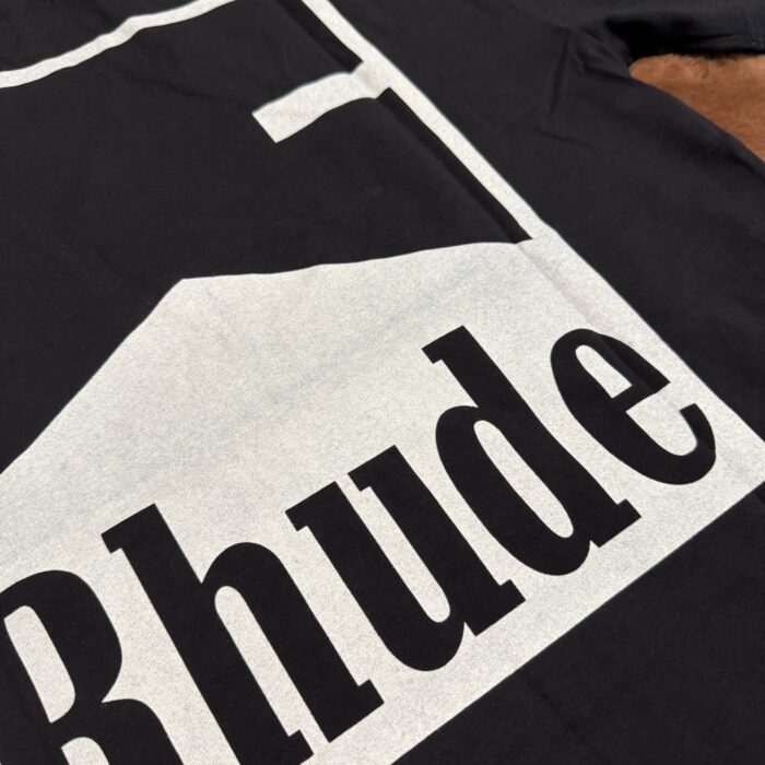 T-shirt nero con grafica montagna e logo Rhude, stile streetwear minimalista e di tendenza.