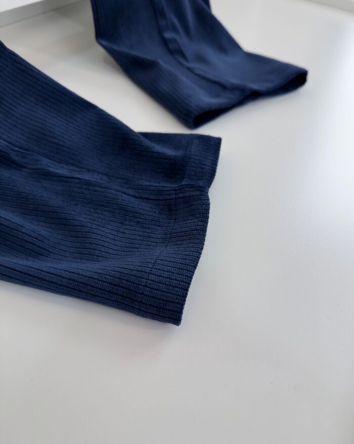 Maniche navy a coste ribbed, tessuto morbido ed elegante per look casual sofisticato.