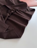 Tessuto marrone lucido con dettagli rosa chiaro, ideale per moda e decorazioni eleganti.