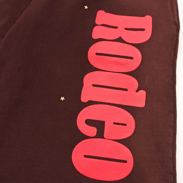 Tessuto marrone con stampa rosa Rodeo, stelle dorate, stile western e abbigliamento casual.