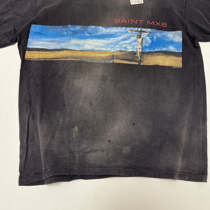 Maglietta vintage nera con paesaggio colorato e silhouette sulla croce, scritta SAINT MXB in rosso.