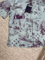 Camicia casual con motivi paesaggistici blu e dettagli in bordeaux, con dettagli artistici e pratici.