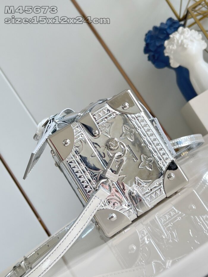Borsa in metallo argento con forma a cubo, dettagli eleganti e stile moderno e sofisticato.