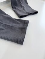 Maniche elasticizzate slim fit in tessuto grigio scuro, ideali per sport e look casual moderni.