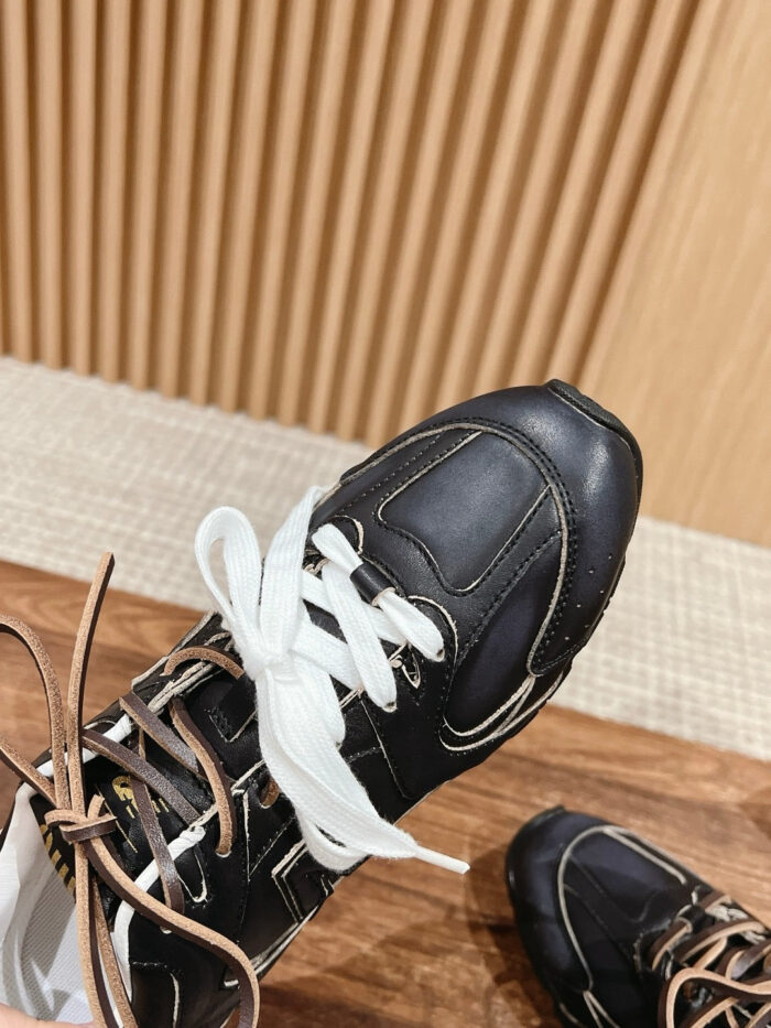Scarpe sportive nere in pelle con dettagli moderni, cuciture contrasto e stile elegante.