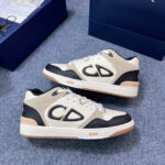 Sneakers beige e nere con logo grande e suola in gomma, ideali per stile casual e sportivo.