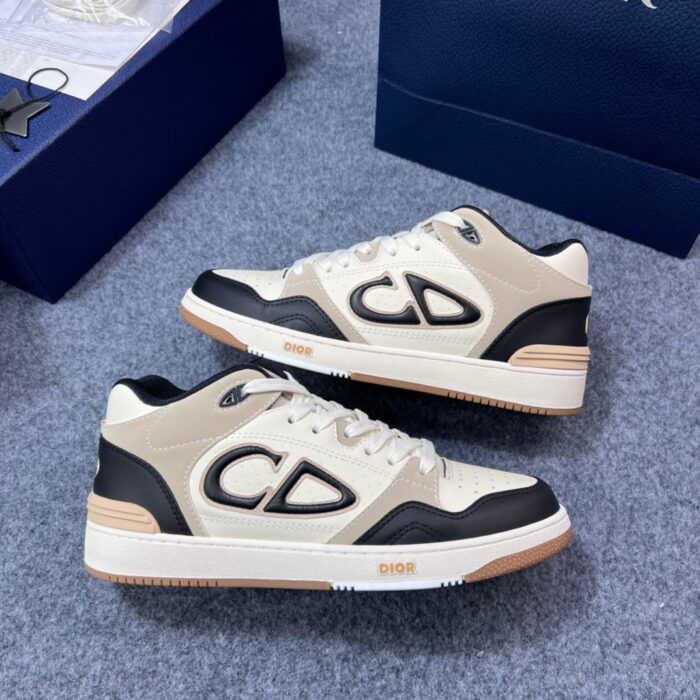 Sneakers beige e nere con logo grande e suola in gomma, ideali per stile casual e sportivo.