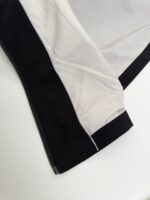 Giacca sportiva nera e bianca, resistente e moderna, perfetta per attività allaperto.