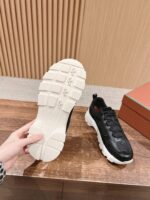 Sneaker moderno nero e bianco con suola robusta e trazione potente.