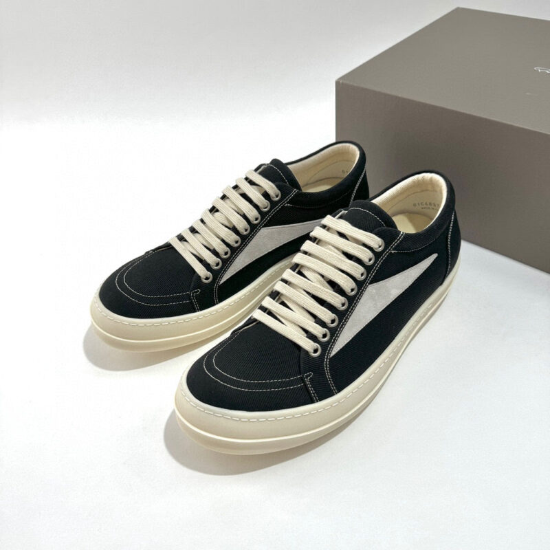 Scarpe sneakers nere e bianche moderne, versatili, con suola chiara e dettagli eleganti.