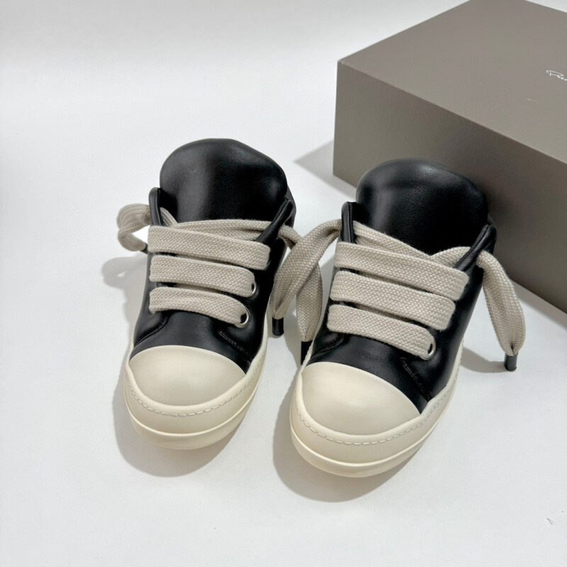 Scarpe sportive nere e beige con design moderno e dettagli eleganti in pelle liscia.