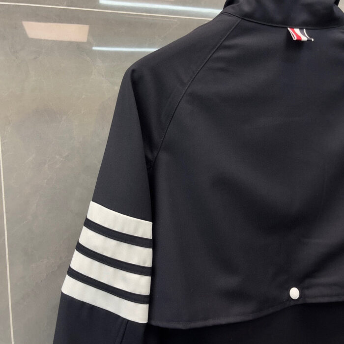 Giacca sportiva nera minimalista con strisce grigie, design moderno e stile athleisure versatile.