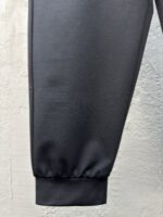 Pantaloni jogger neri con polsino elasticizzato, tessuto lucido e design moderno.