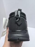 Scarpa sportiva nera con pull tab riflettente, suola ammortizzante e traspirante per sport e casual.