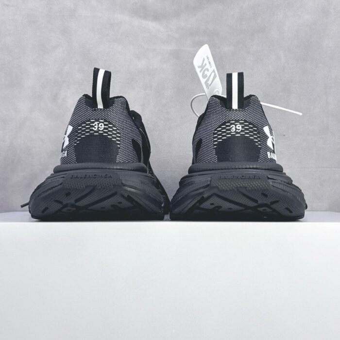 Scarpe da corsa nere moderne con dettagli riflettenti, suola resistente e logo visibile.