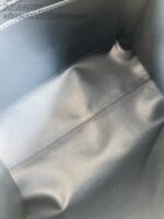 Interno di borsa nera minimalista in tessuto sintetico, con cuciture solide e design elegante.