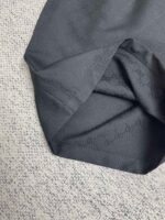 Tessuto nero delicato con dettagli finemente intrecciati e finiture di alta qualità.