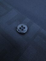 Bottoni neri eleganti su tessuto navy, dettaglio di alta qualità e stile raffinato.