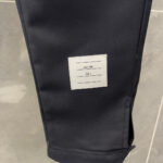 Pantaloni neri slim con etichetta minimalista e polsino, tessuto elegante e moderno.
