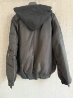 Giacca nera con cappuccio, design minimalista e tasca laterale, perfetta per uno stile casual e moderno.