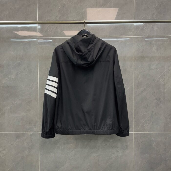 Giaccone nero sportivo con cappuccio, strisce bianche e design moderno e versatile.