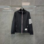 Giacca nera sportiva con cappuccio, strisce bianche e design minimalista elegante.