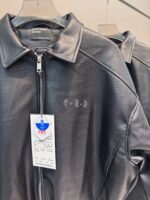 Giacca in pelle nera moderna ed elegante con logo discreto, perfetta per look sofisticati.