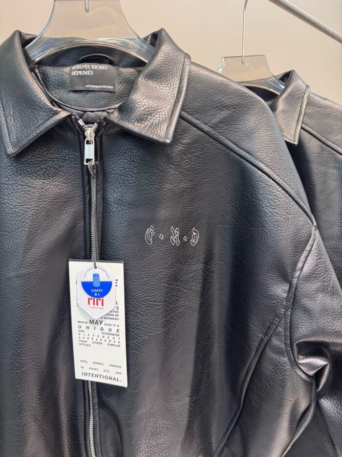 Giacca in pelle nera moderna ed elegante con logo discreto, perfetta per look sofisticati.