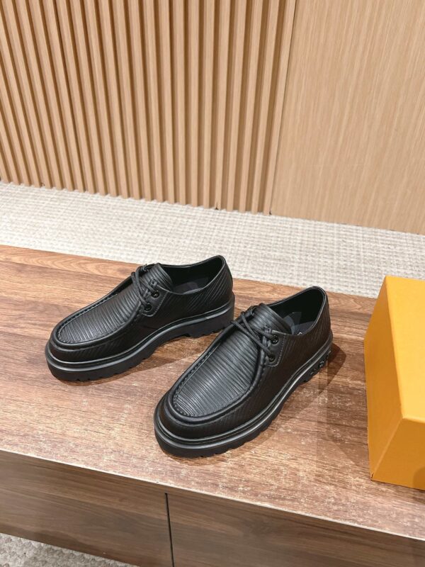 Scarpe in Pelle Nera Eleganti su superficie di legno con dettagli di stile e design raffinato.