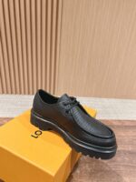 Scarpa elegante in pelle nera su scatola arancione, stile versatile e raffinato.