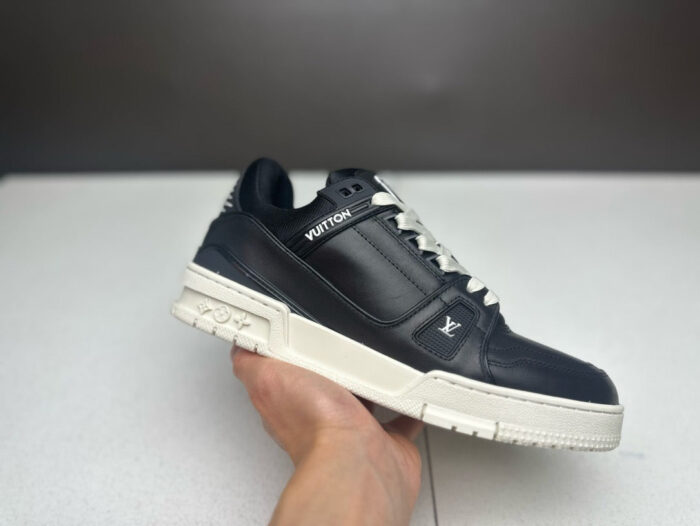 Sneaker di pelle nera elegante con suola bianca, stile moderno e dettagli di lusso.