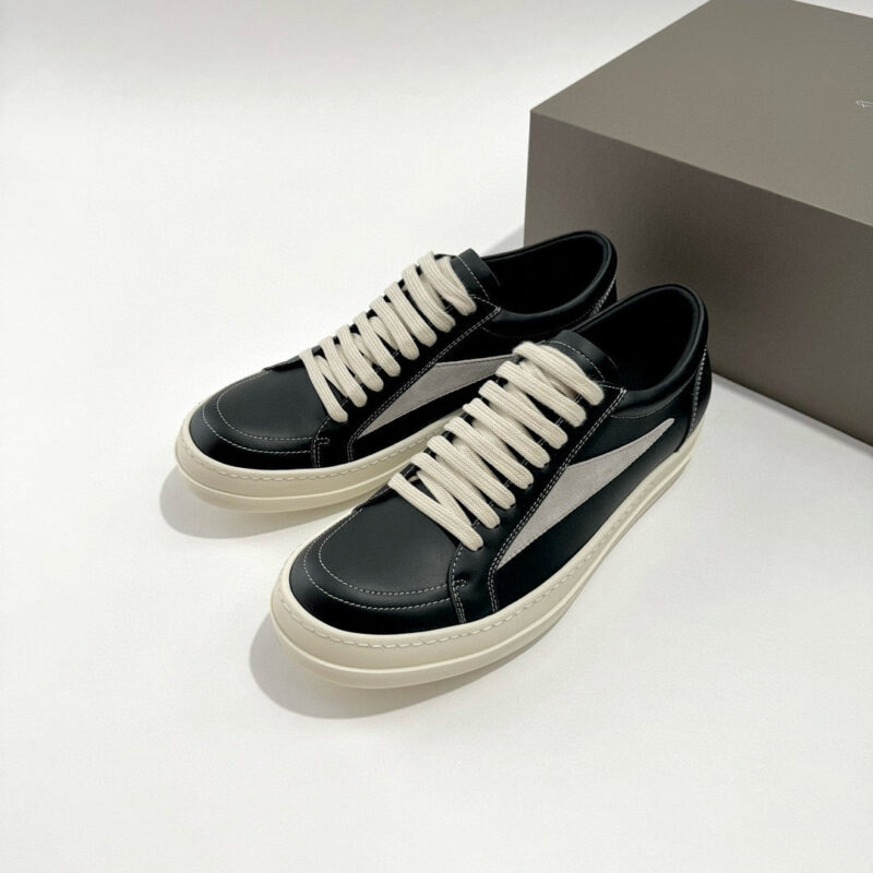 Sneakers nere in pelle con banda bianca e lacci crema, stile moderno e versatile.