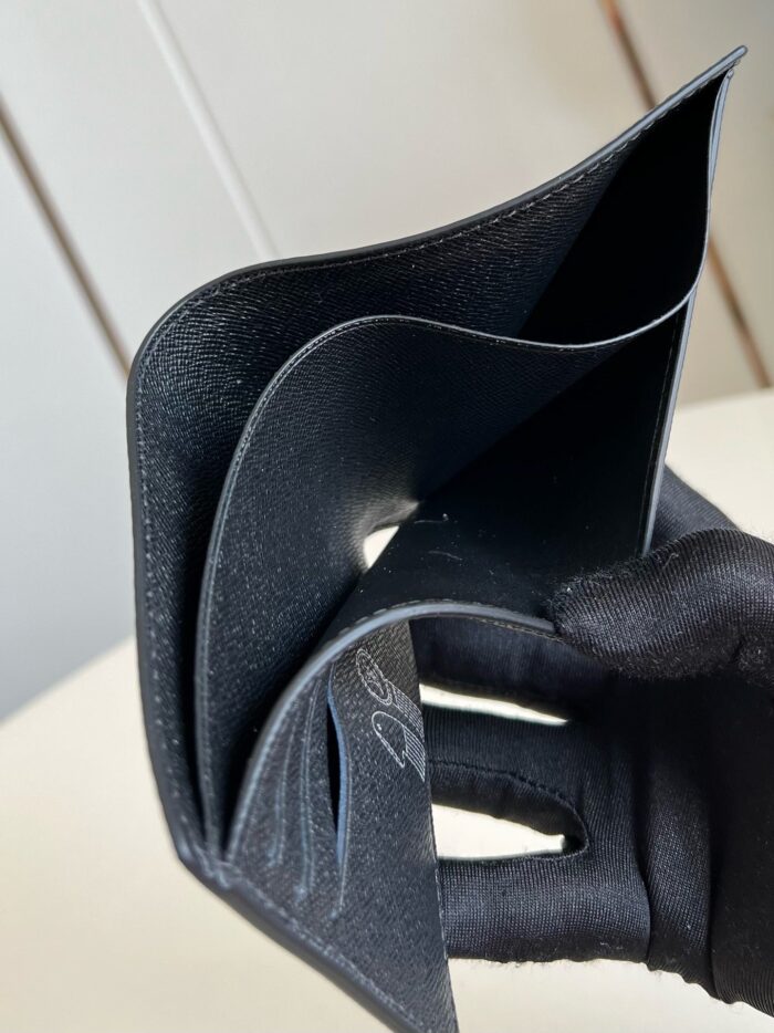 Portafoglio minimalista nero in pelle con design elegante, tenuto da mano con guanto in vista di lusso.
