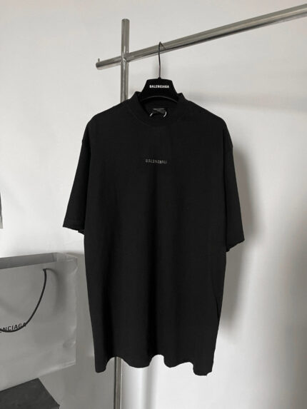 Polo nero minimalista da uomo, elegante e casual, tessuto morbido, logo discreto, stile oversize.