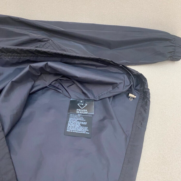 Giacca nera in nylon con dettagli elastici, stile minimalista e stile adatto a ogni occasione.