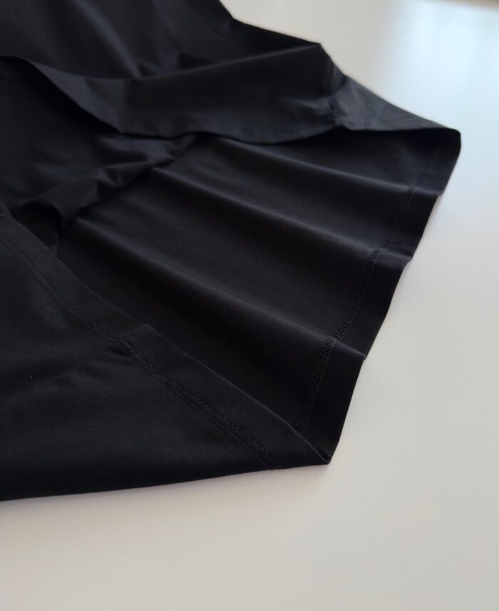 Tessuto nero con pieghe eleganti, logo discreto, ideale per look raffinati e di qualità.