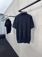Magliette polo nere classy su appendiabiti minimalisti in ambiente moderno ed elegante.