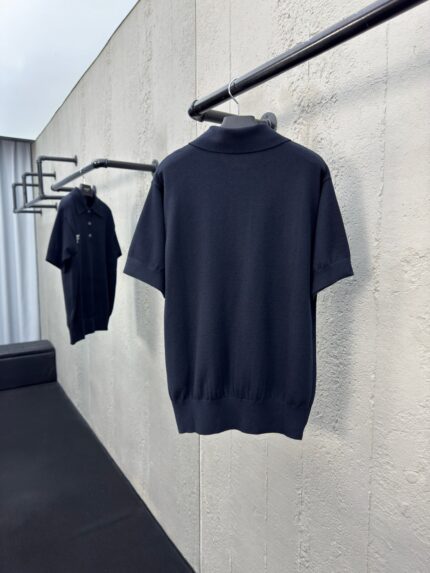 Magliette polo nere classy su appendiabiti minimalisti in ambiente moderno ed elegante.