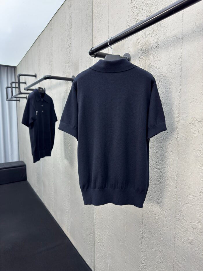 Magliette polo nere classy su appendiabiti minimalisti in ambiente moderno ed elegante.